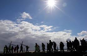 Persone in pellegrinaggio con la croce