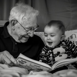 nonno e nipote stesi sul letto ad leggere storie